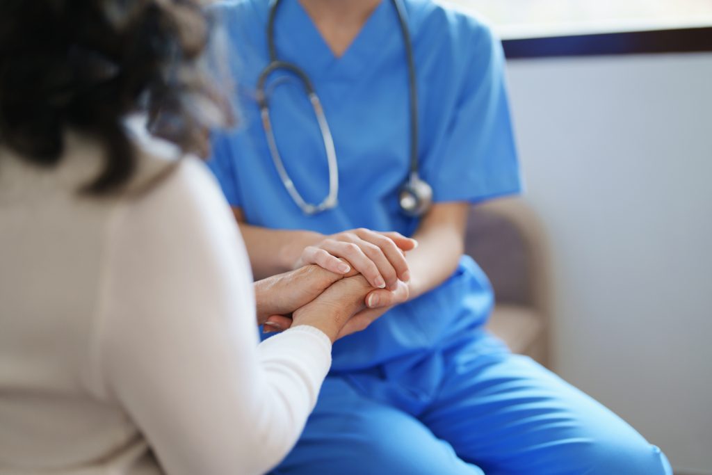 médecin tenant la main d'une patiente