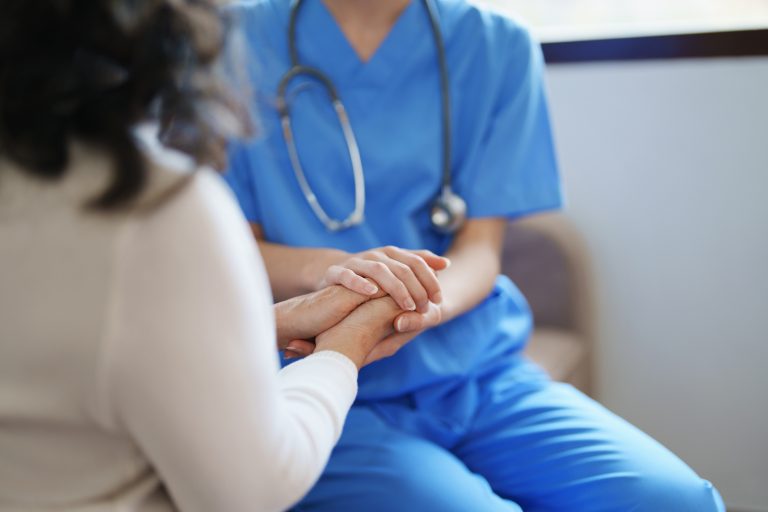 médecin tenant la main d'une patiente