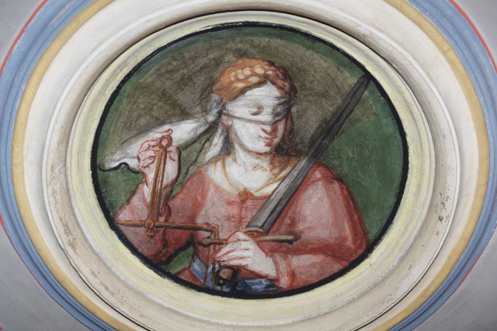 Portrait de femme représentant la justice portant une balance, armée d'une épée et les yeux bandés.