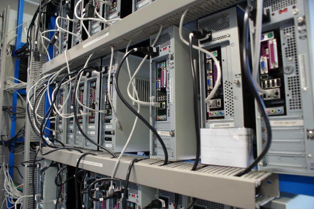 Rangées de serveurs en rack et câbles dans un centre de données moderne.